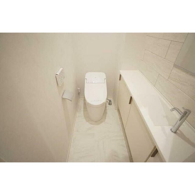 トイレの様子です。壁付リモコンの洗浄機能付き便座です。手洗機もあります。(内装)